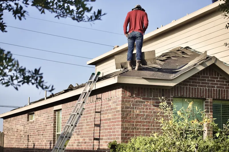Professional roofer working on a residential roof in Five Points